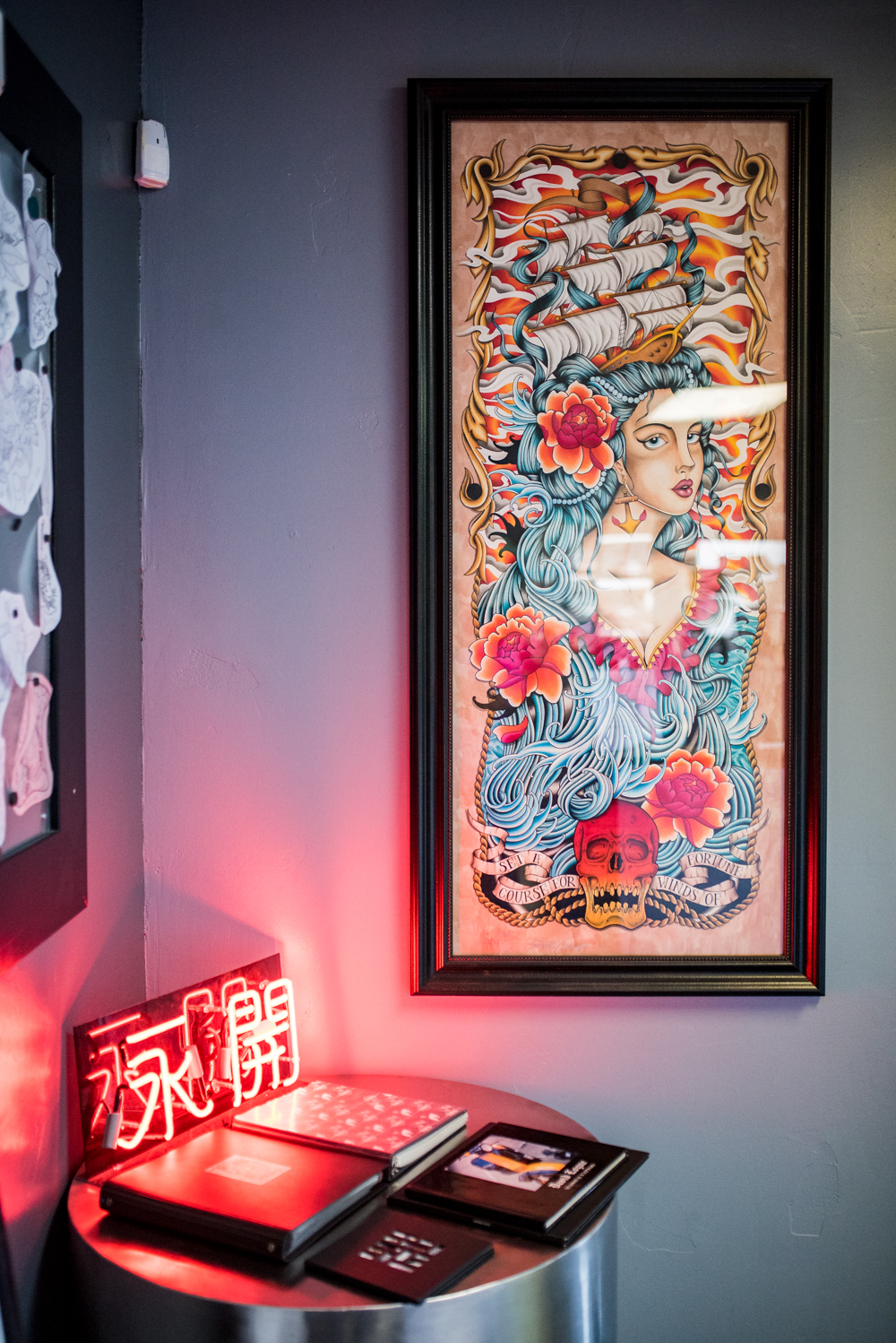 Vibrant traditional tattoo flash art framed on studio wall
